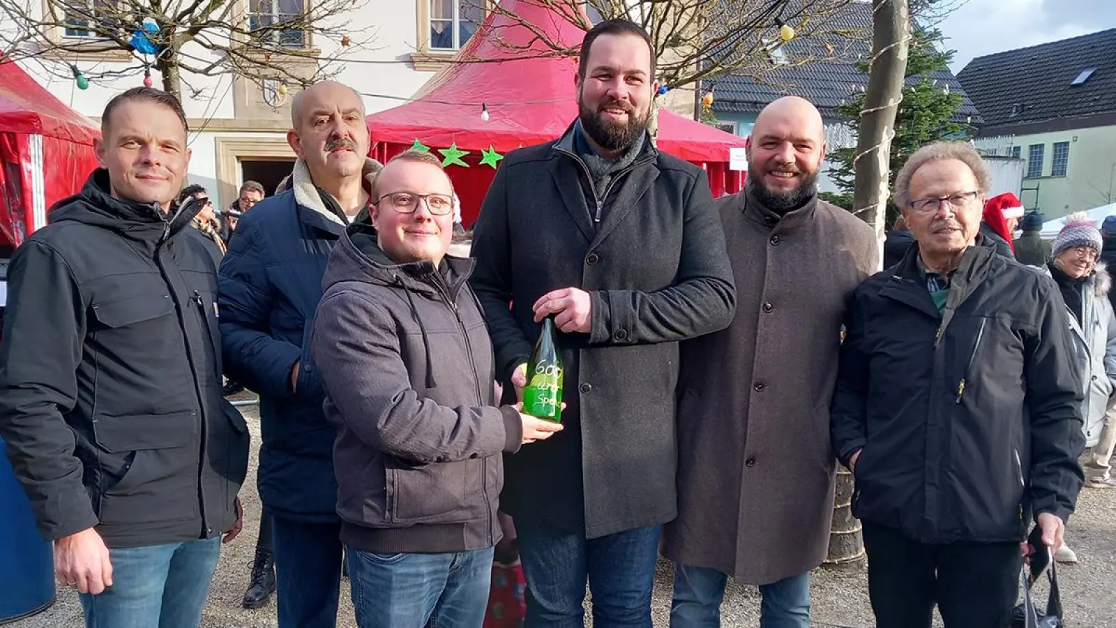 Wein und Spende: Daniel Heublein, Zweiter Vorstand der Wahlgemeinschaft, bei der Spendenübergabe an Bürgermeister Christian Brunner. (Foto: Redaktion Bindlach)