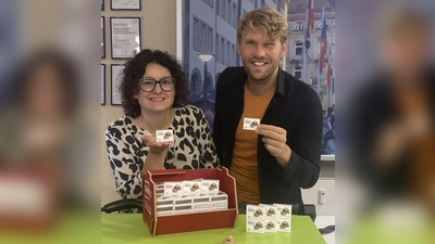 Sandra Baumann, Leiterin der Tourist Information, und Florian André Unterburger, Projektleiter des Jubiläums, präsentieren das neue Souvenir „Festspielhaus in der Streichholzschachtel“. (Foto: Stadt Bayreuth)