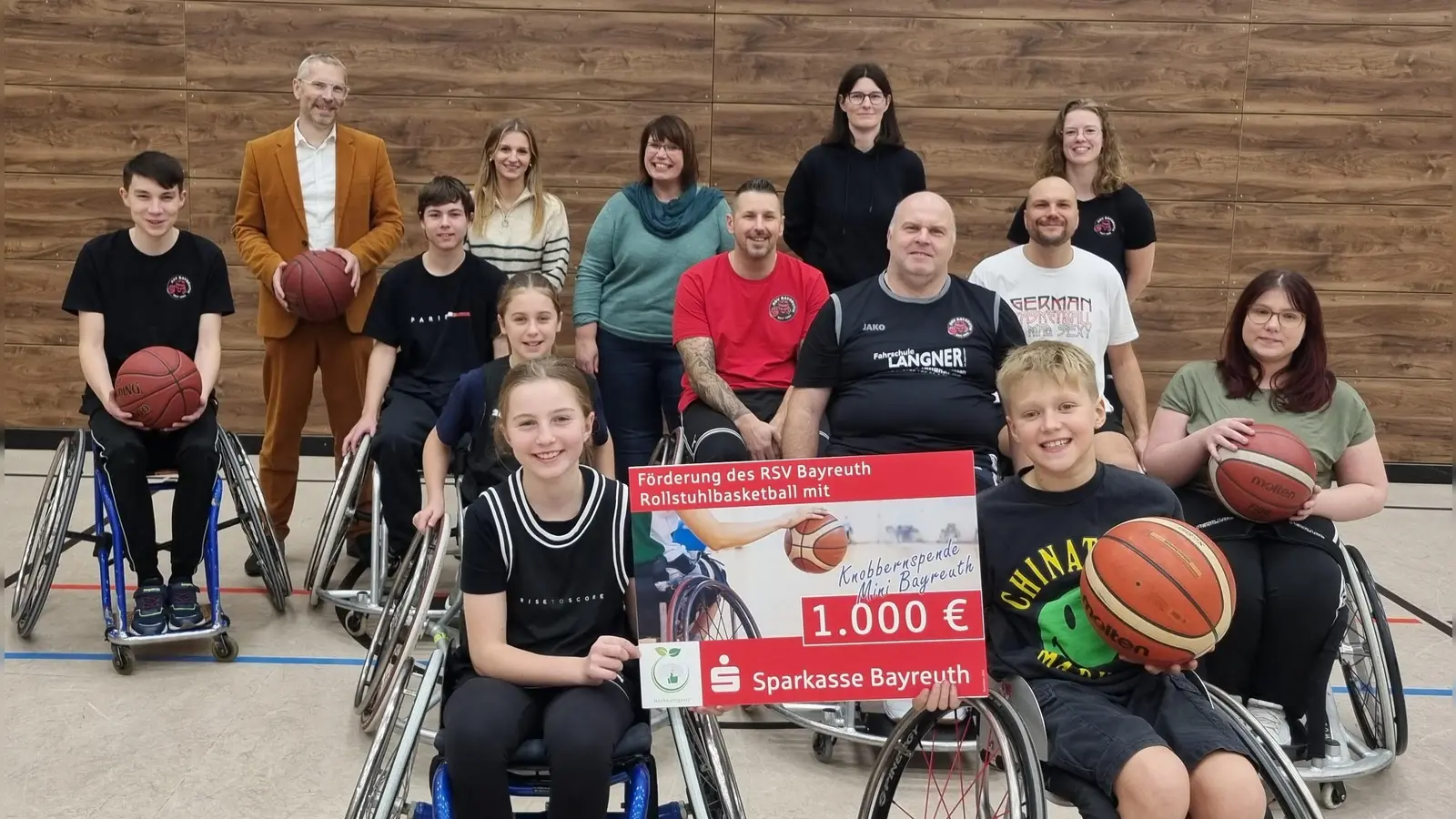 Sie freuen sich über die Knobbern-Spende (hinten von links): Markus Zweck (Sparkasse Bayreuth), Marie Ganzleben (Leiterin „Mini-Bayreuth“), Nancy Kamprad (Vorsitzende Stadtjugendring Bayreuth) sowie (hinten rechts) Dagmar van Hinte (Projektleitung Rolli Bears) mit jungen Mitgliedern der Rolli Bears. (Foto: Stadtjugendring Bayreuth/Melanie Teufel)