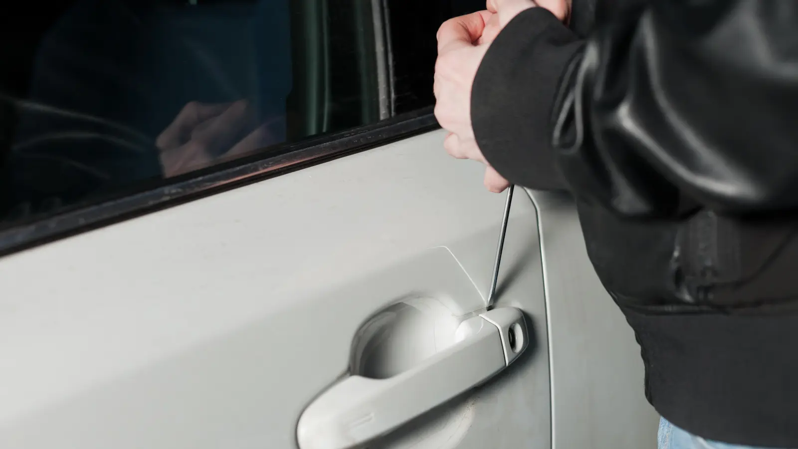 Male thief hands trying to open car door with screwdriver. Carjacker unlock vehicle. Carjacking danger (Foto: inBayreuth.de)