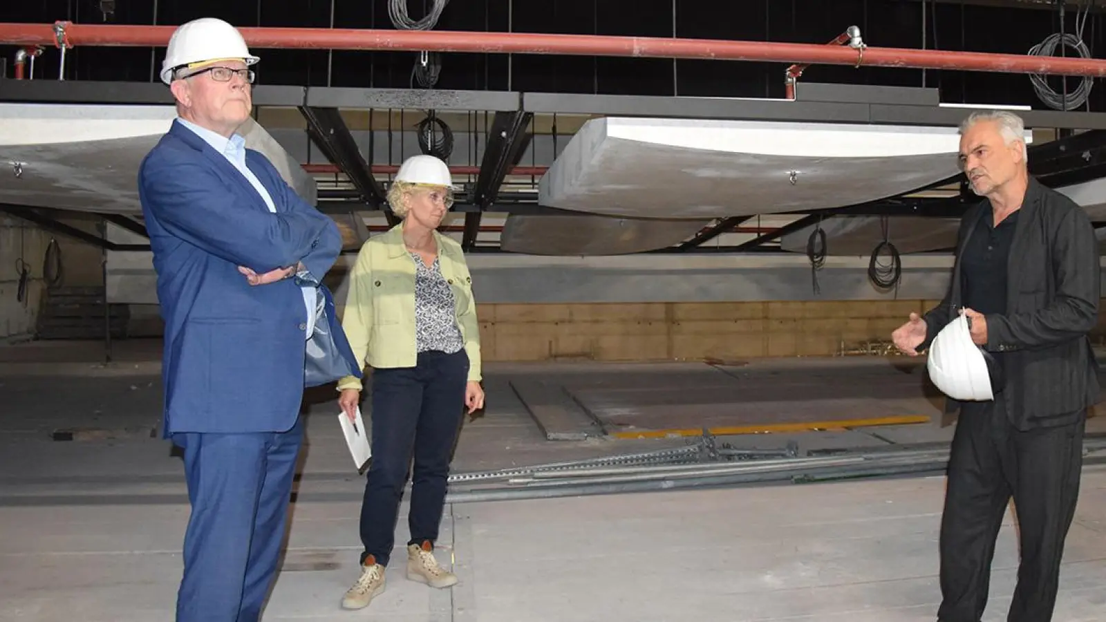 Lauschen direkt unter der Decke im Großen Haus bei der Baustellenführung den Ausführungen von Architekt Thomas Knerer (re.): OB Thomas Ebersberger und Baureferentin Urte Kelm. (Foto: Lenkeit)