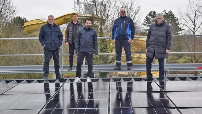 Rutsche im Rücken, Photovoltaik zu Füßen: von links von den Stadtwerken Bayreuth Jürgen Bayer (Geschäftsführer), Juri Kolodi und Dirk Korth (beide Vertrieb Energiedienstleistungen), Uwe Kasel (Leiter Kreuzsteinbad) sowie Oberbürgermeister Thomas Ebersberger. (Foto: Lenkeit)