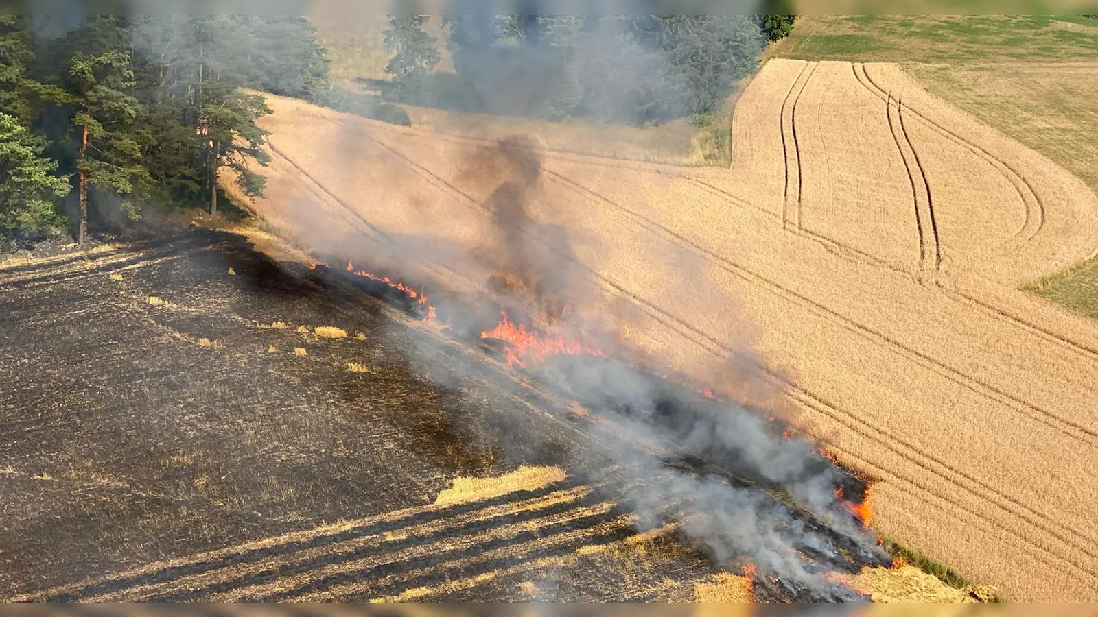 Ein brennendes Feld unweit eines Waldgebiets in Oberfranken.  (Foto: Jörg Herrmannsdörfer, Luftrettungsstaffel Bayern ? Standort Mistelgau)