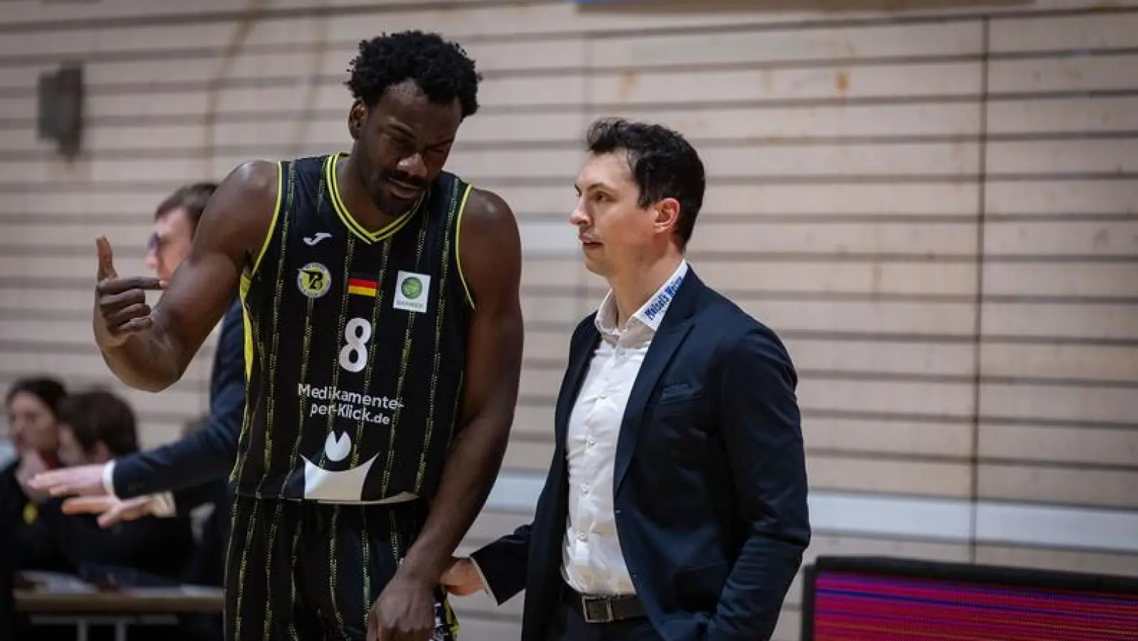 Lukas Hofer (rechts, hier beim Spiel in Kirchheim im Gespräch mit Nat Diallo) wird offiziell bis Saisonende als neuer Headcoach des BBC Bayreuth fungieren, links, leicht verdeckt, sein Assistent Nils Scheller. (Foto: Nina Sander)