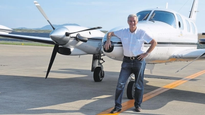 Reiseunternehmer und Stifter Reiner Meutsch vor seinem Flugzeug. (Foto: FLY & HELP)