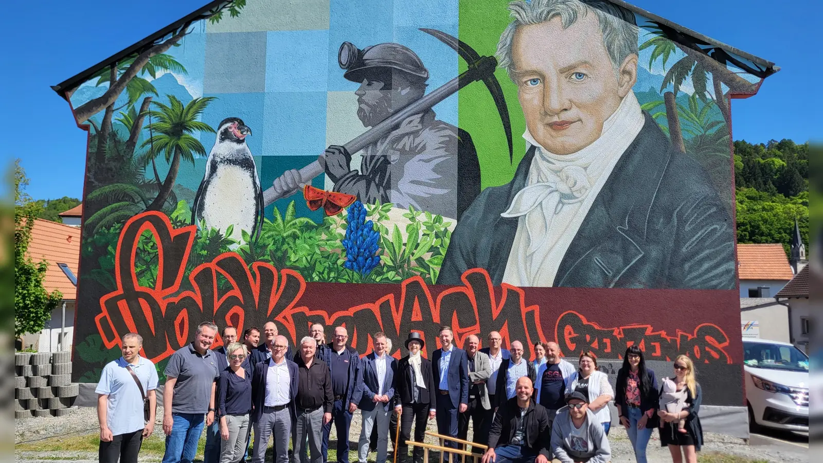 Alle sind mächtig stolz auf den neuen „Hingucker“ in Goldkronach: Landrat Florian Wiedemann, Bürgermeister Holger Bär, die Künstler Volker Wunderlich und Fabian Lüttge (beide auf der Leiter sitzend) sowie weitere Vertreter aus Kommunalpolitik und Kreisverwaltung posieren vor dem neuen Kunstwerk für ein Foto. (Foto: red )