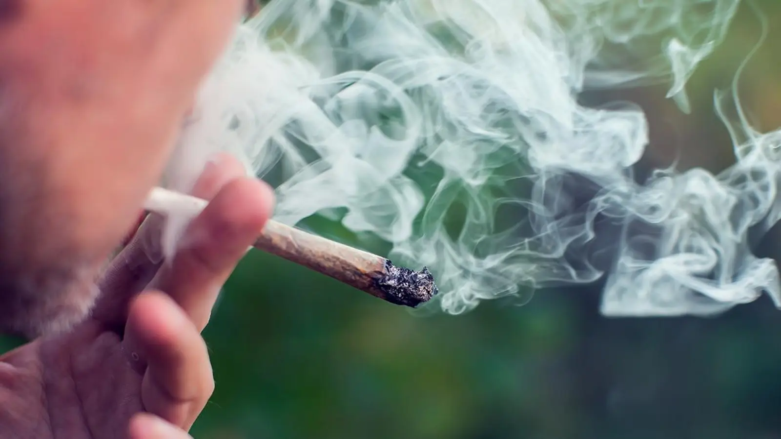 Mann beim Konsum eines Joints: Die Polizei muss seit 1. April die Einhaltung zulässiger Mengen kontrollieren. (Symbolbild: Adobe Stock/Alexej)