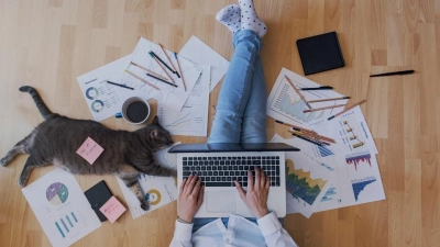 creative home work space – work from home concept – girl with cat (Foto: ©Alberto Grosescu / AdobeStock)