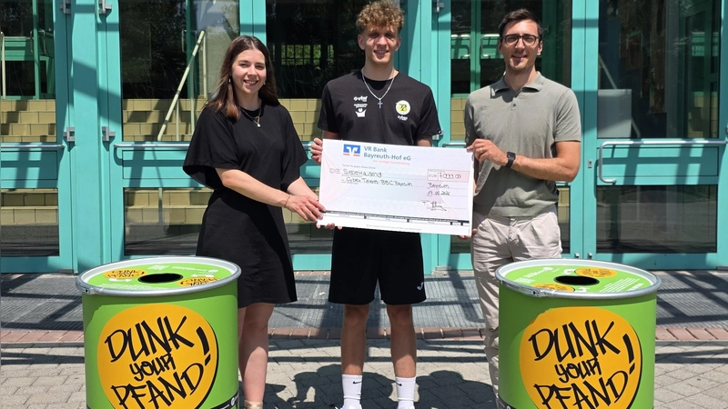 Helena Großmann (Unternehmenskommunikation Energiehaus Deutschland), Liam Holländer (Teamkapitän &amp; Topscorer NBBL) und Friedrich Hartung (Geschäftsführer BBC Bayreuth Spielbetrieb GmbH, von links) bei der Spendenübergabe.  (Foto: BBC Bayreuth)