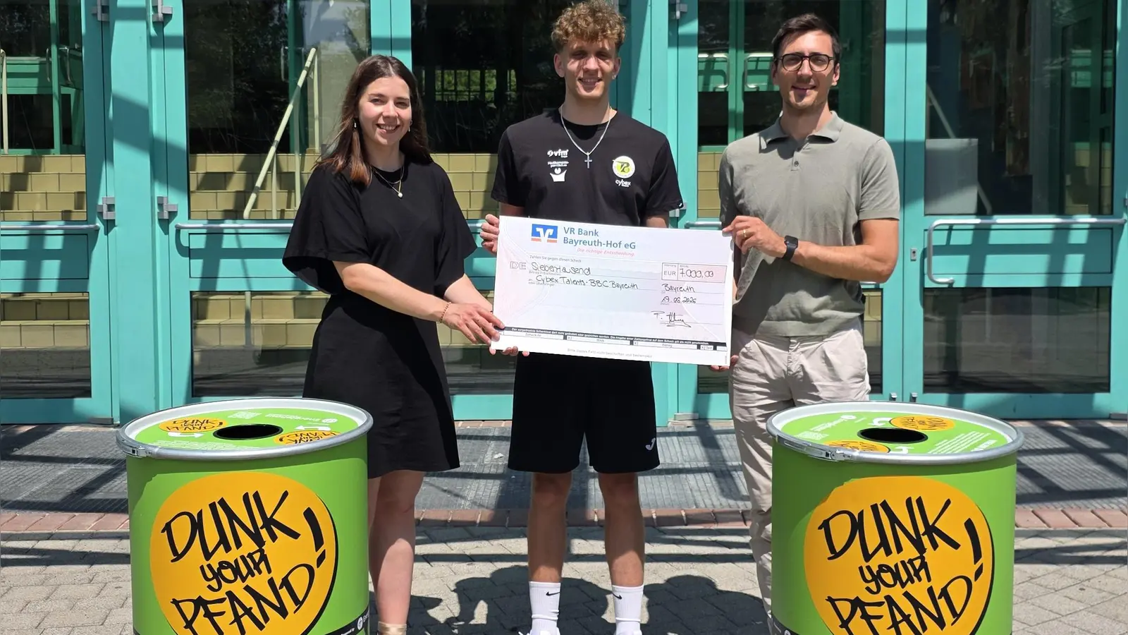 Helena Großmann (Unternehmenskommunikation Energiehaus Deutschland), Liam Holländer (Teamkapitän &amp; Topscorer NBBL) und Friedrich Hartung (Geschäftsführer BBC Bayreuth Spielbetrieb GmbH, von links) bei der Spendenübergabe.  (Foto: BBC Bayreuth)