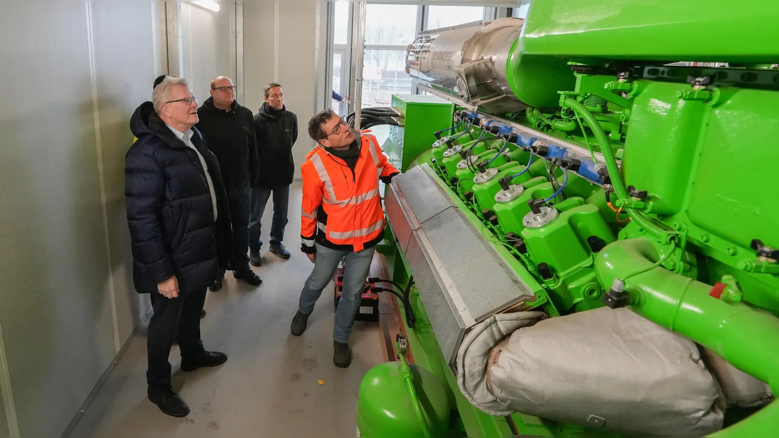 Lothar Ziegler (v. re.), der Leiter des Klärwerks, erläutert zusammen mit dem Leiter des Tiefbauamts der Stadt Bayreuth, Christoph Batschkat, und Projektleiter Volker Stolbinger (ebenfalls Tiefbauamt) Oberbürgermeister Thomas Ebersberger die Funktionsweise eines der drei Blockheizkraftwerke der neuen Energiezentrale, die gerade in den Probebetrieb gegangen ist. (Foto: Stadt Bayreuth)