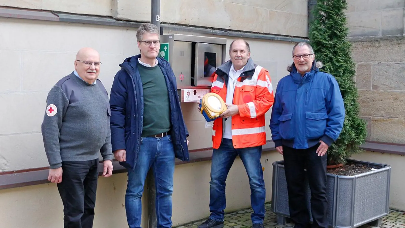 Von links: Hermann Maier (BRK-Ausbilder), Bernhard Leutheusser (Geschäftsführer Hartsteinwerke Schicker), Karl Bernet (Projektkoordinator Defi-Netzwerk Bayreuth) und Jürgen Zinnert (Bürgermeister Bad Berneck). (Foto: Tobias Schif/BRK Bayreuth)
