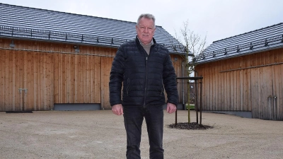 Bürgermeister Robert Pensel im Hof zwischen Dorfgemeinschaftshaus und Kulturscheune. Auf Scheune (links) und Lagergebäude (rechts) sind die Solarkollektoren angedacht. (Foto: Lenkeit)