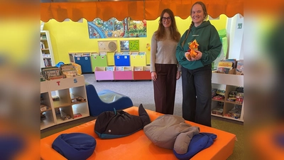 Kathrin Weishäupl (li.) von Miss Smarthead GmbH übergibt das Kuschelnest an Kinderbibliotheksleitung Alexandra Warzecha. (Foto: RW21 Stadtbibliothek)