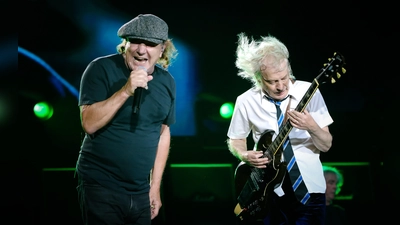 AC/DC bei einer Liveshow im Oktober 2023 im unverwechselbaren Look: Sänger Brian Johnson mit Schiebermütze, Leadgitarrist Angus Young in Schuluniform. (Foto: Christie Goodwin)