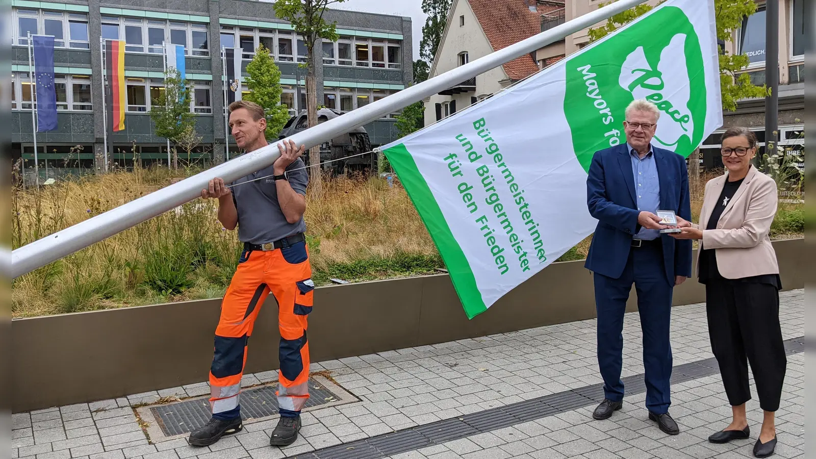 Oberbürgermeister Thomas Ebersberger und Künstlerin Lucie Kazda beim Hissen der Flagge „Mayors for Peace“.  (Foto: Stadt Bayreuth )