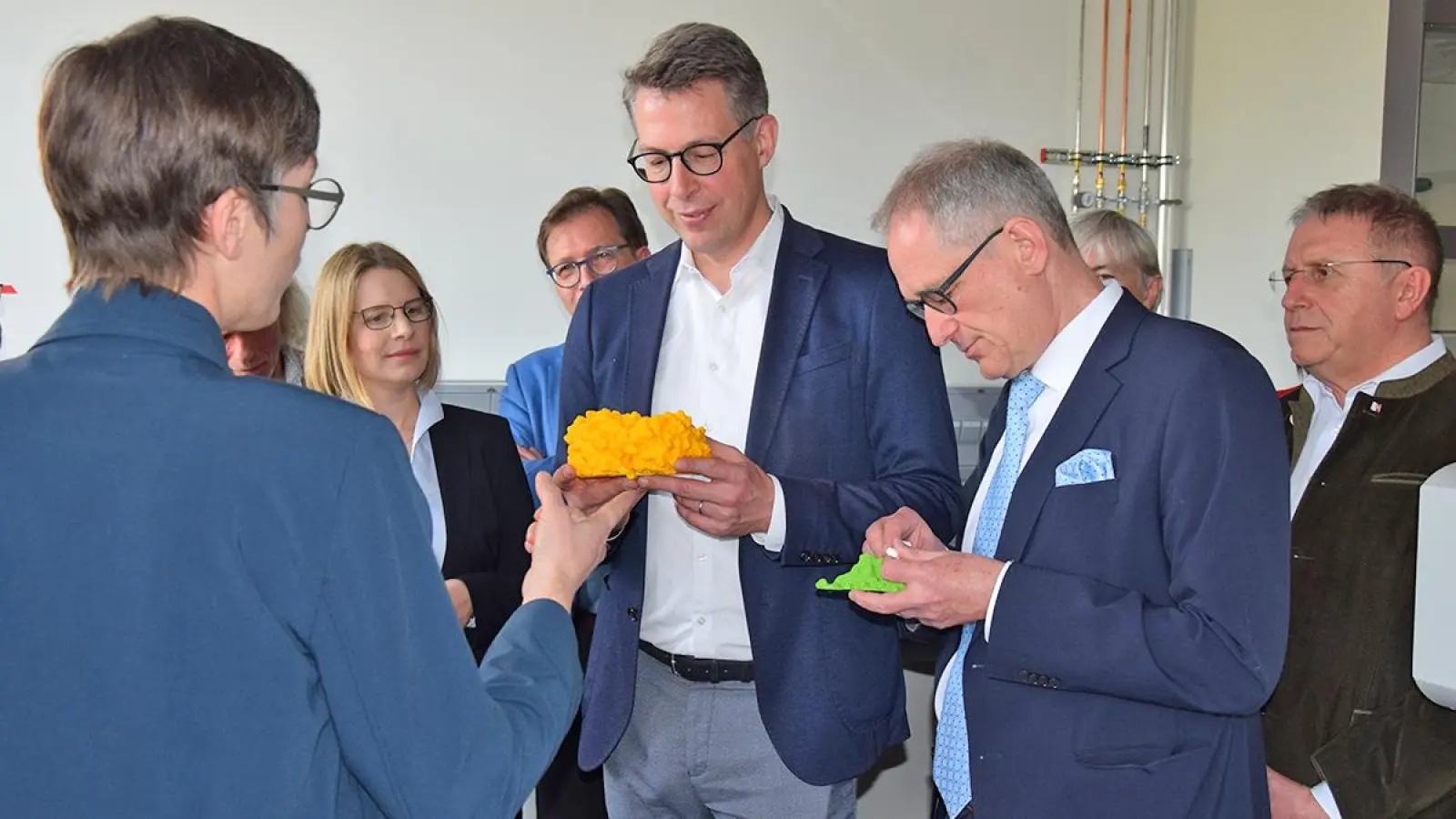 Rekonstruktion von Gewebe erklärt am Modell: Prof. Dr. Birte Höcker gibt Wissenschaftsminister Markus Blume und Universitätspräsident Markus Blume Anschauungsunterricht. Im Hintergrund: Kanzlerin Dr. Nicole Kaiser, MdL Franc Dierl, Regierungsvizepräsident Thomas Engel und Bezirkstagspräsident Henry Schramm. (Foto: Lenkeit)