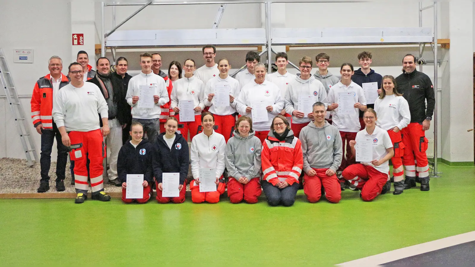 Die 16 neuen Sanitäterinnen und Sanitäter, das Team der Ausbilderinnen und Ausbilder um Oliver Heinz, Bernd Neukam (BRK-Kreisbereitschaftsleiter Bayreuth) und seine Stellvertreter Mischa Nietfeld und Patrick Czekalla, Dr. Christian Birnmeyer (BRK-Chefarzt Bayreuth) und Tanja Peplau (stv. technische Leiterin Kreiswasserwacht Bayreuth). (Foto: Florian Förster /BRK-Bayreuth)