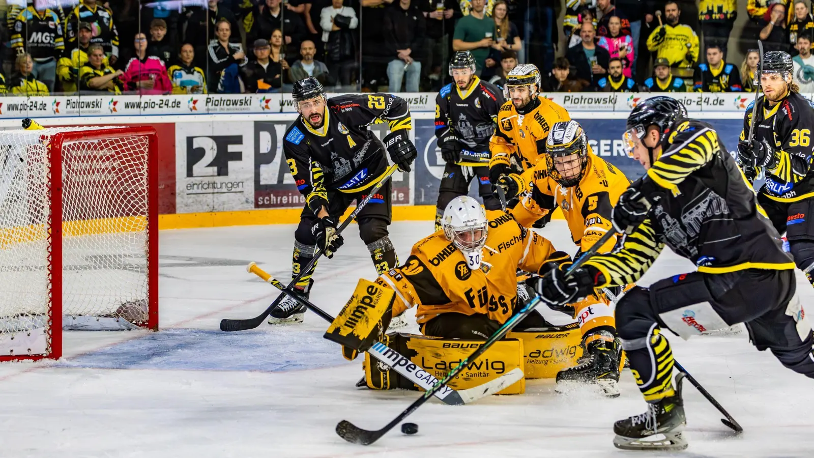 Dominik Piskor (im Vordergrund, an der Scheibe, hier im Heimspiel gegen den EV Füssen) war auch einer der Bayreuther Torschützen in Höchstadt. (Foto: Dirk Ellmer)
