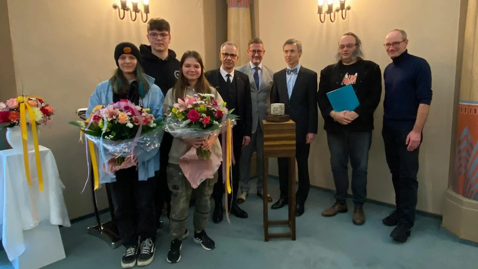 Ein zu behauender Stein als Preis. Um ihn herum von links: Auriel Funsch, Kendrik Raps, Savannah Bernet, Stefan Kunnert (Großmeister einer der deutschen Großlogen), Komponist Hans Martin Gräbner, Prof. Dietmar Boerner (Meister vom Stuhl der Bayreuther Loge „Eleusis zur Verschwiegenheit”), Peter Weintritt (Vorstand Schoko e.V.), Laudator John von Düffel. (Foto: Lenkeit)